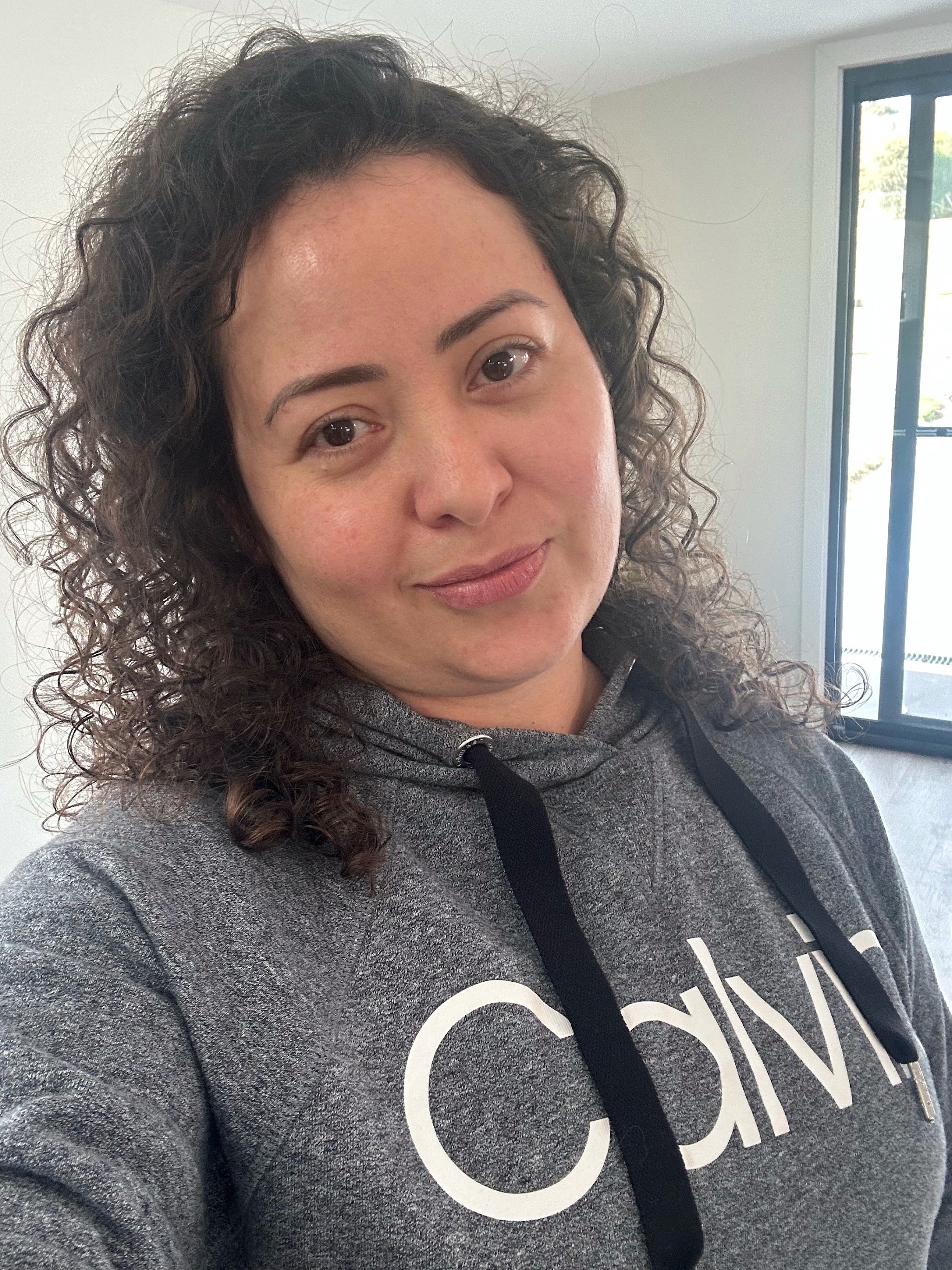 A client showing off her defined curls after her appointment